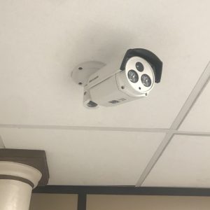 Caméra de vidéosurveillance tube sur le plafond afin de surveiller l'entrée d'un magasin.